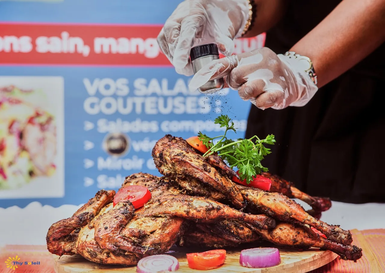 Assiette de viande grillée avec des légumes sur un plateau noir.